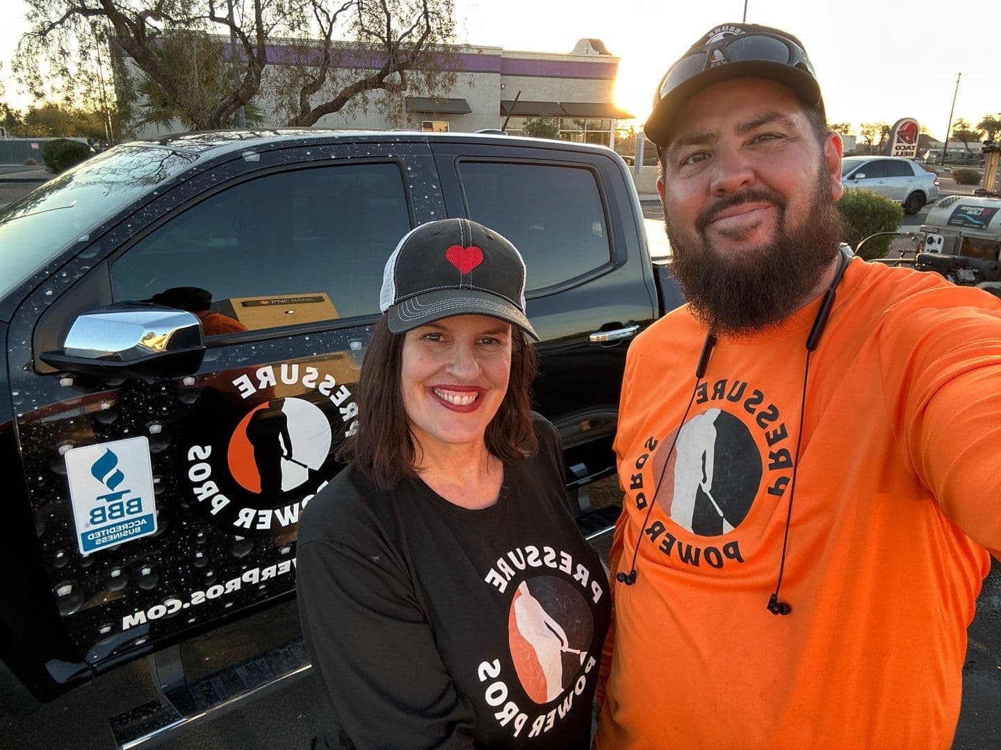 The owners of Mesa Power Wash beside their branded truck, a BBB Accredited Business